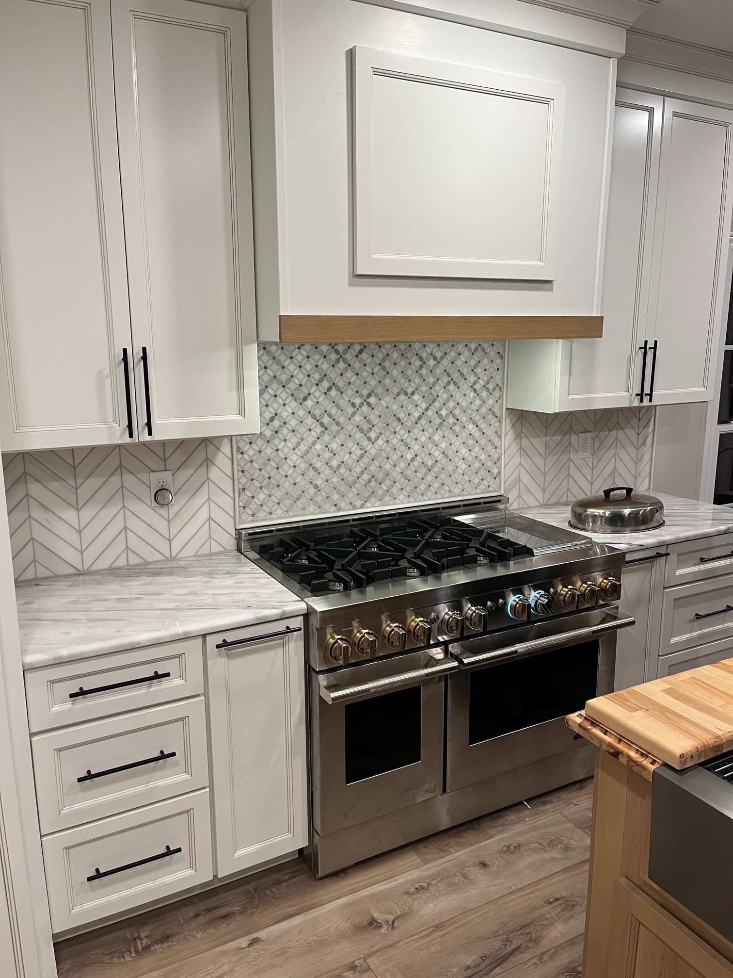 Kitchen with professional range, marble surfaces, and refined finish detailing